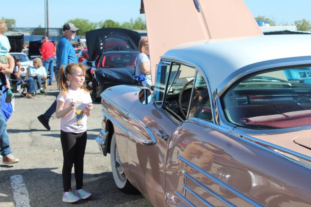 Brynley Stroud, 6, of McLoud, takes down the information from a 1958 Oldsmobile Holiday Coupe, belonging to Gayla Hays, so she can vote for it to receive the Kids Choice Award. The pink and white coupe was one of 136 vehicles in the Eighth Annual Bethel Band Boosters Car Show Fundraiser on April 13. Countywide &amp; Sun/Natasha Dunagan