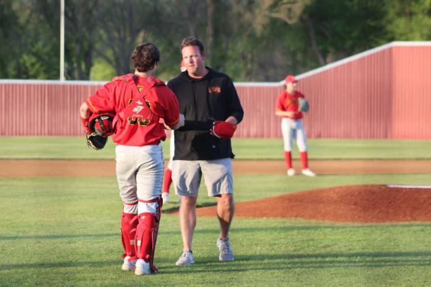 After throwing out the first pitch for the home game on April 8, Dale 2001 Graduate Eric Thornton shakes hands with Dale senior and catcher Ethan Douglas. Thornton was honored for his baseball record of five state championships and presented with a game ball and hat. Countywide &amp; Sun/ Natasha Dunagan