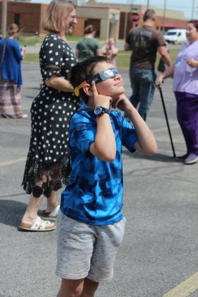 Daniel Beard, 7, of Seminole, checks out the total solar eclipse during the Tecumseh Public Library Eclipse Viewing Party, held at the Tecumseh Pentecostal Church of God parking lot on April 8. The library provided solar eclipse glasses, Moon Pie and Star Crunch snacks. Countywide & Sun/Natasha Dunagan
