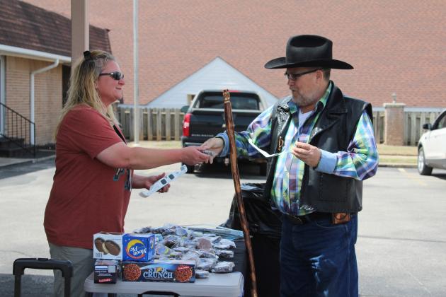 Library employee Sara McGaha hands a Star Crunch to Mickey Davis of Tecumseh during the Tecumseh Public Library Eclipse Viewing Party, held at the Tecumseh Pentecostal Church of God parking lot on April 8. The library also provided solar eclipse glasses. Countywide & Sun/Natasha Dunagan