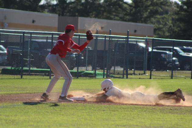 Tecumseh junior Caleb Sparks dives into third base as North Rock Creek freshman Landon Rosser makes the catch during the April 4 game at Tecumseh. The Cougars won, 3-0. Countywide &amp; Sun/Natasha Dunagan