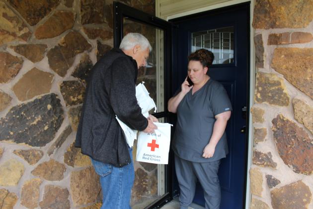 Mayor Ed Bolt talks with Taylor Cline as he hands her a resource information bag during the United Way of Pottawatomie County Longterm Recovery Group Tornado Outreach on April 15. During the outreach, 23 volunteers knocked on 407 doors to share the bags of resource and disaster preparedness information. Countywide &amp; Sun/Natasha Dunagan