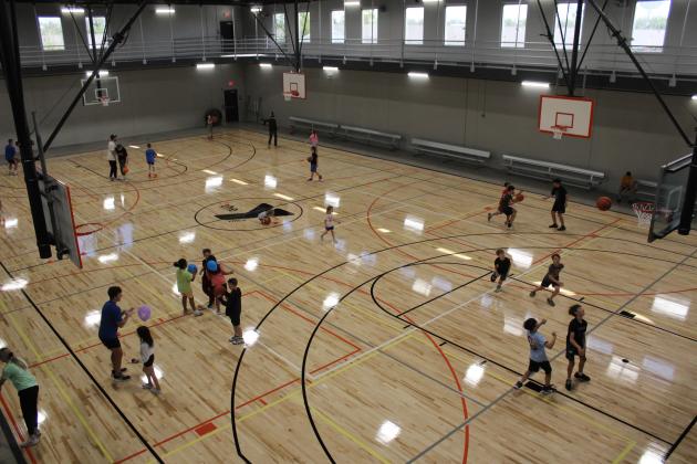Children and adults have fun on the new basketball court at the Troy and Dollie Smith Family YMCA during the Grand Reopening Party on April 6. Shawnee YMCA CEO Mike Jobe said there were approximately 1,800 people at the event. Countywide &amp; Sun/Natasha Dunagan