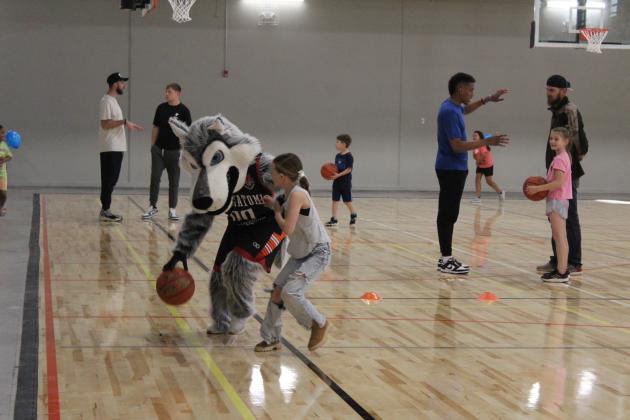 Taiyn Masoner, 8, of Tecumseh, plays one-on-one basketball with Mo, the Potawatomi Fire Wolf, on the new basketball court at the Troy and Dollie Smith Family YMCA during their Grand Reopening Party, April 6. Countywide &amp; Sun/Natasha Dunagan