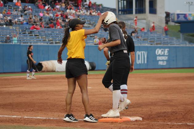 Freshman Madison Gray gets a pat on the helmet from Assistant Coach Kayla Rodriguez.
