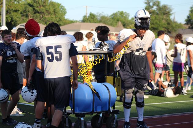 Players on the Shawnee High School Wolves Football Team get a drink during the Spring Game fundraiser on May 18, when they got to play on the new turf at Jim Thorpe Stadium for the first time. The entry fee was donations of laundry soap, bottled water, sports drinks or packaged snacks. Countywide &amp; Sun/Natasha Dunagan