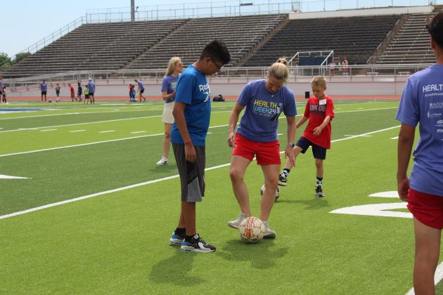 Two-time US Olympic Gold-medalist and U.S. Women’s Soccer Legend Lindsay Tarpley gives demonstration to a crowd of kids.