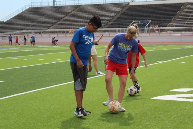 Two-time US Olympic Gold-medalist and U.S. Women’s Soccer Legend Lindsay Tarpley gives demonstration to a crowd of kids.