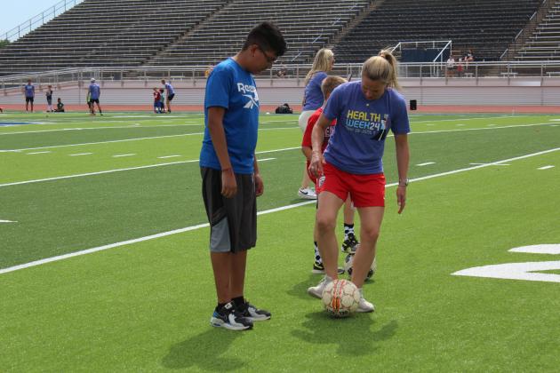 Two-time US Olympic Gold-medalist and U.S. Women’s Soccer Legend Lindsay Tarpley gives demonstration to a crowd of kids.
