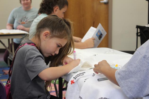 Abby Gregory, 5, of Shawnee, colors her emergency pillowcase at the Shawnee Public Library on April 27. Red Cross Disaster Program Manager Sherry Schauer and volunteers Becky Miller and Ray Schachner spoke to about eight children and their parents on being prepared for a tornado. For the Red Cross Pillowcase Project, the children could decorate a pillowcase and put emergency supplies (some included) and other items they wish to take with them inside.