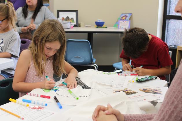 Mackenzie Norton, 6, and Avery Norton, 9, both of Shawnee, color their emergency pillowcases at the Shawnee Public Library on April 27. Red Cross Disaster Program Manager Sherry Schauer and volunteers Becky Miller and Ray Schachner spoke to about eight children and their parents on being prepared for a tornado. For the Red Cross Pillowcase Project, the children could decorate a pillowcase and put emergency supplies (some included) and other items they wish to take with them inside.