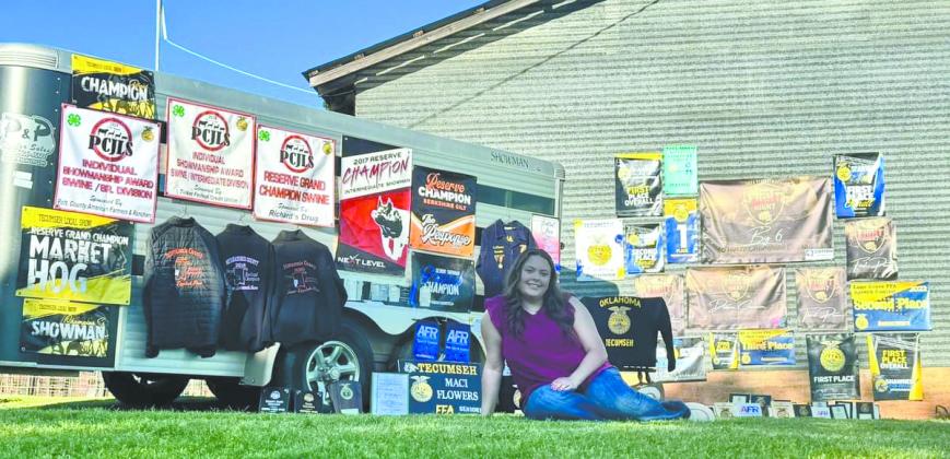 Tecumseh graduate Maci Flowers poses with all of her awards - including banners, plaques and jackets - earned during her time in Tecumseh High School FFA. She estimates there are between 40 and 45 awards. Flowers recently received her State FFA Degree with an Academic Excellence recognition, as well as a Career Passport in the area of Ag Communications. Photo provided.