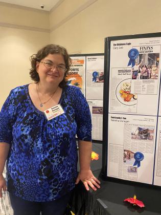 Natasha Dunagan poses beside her first-place business story at the OPA Convention June 8. Countywide &amp; Sun/Julie Talton