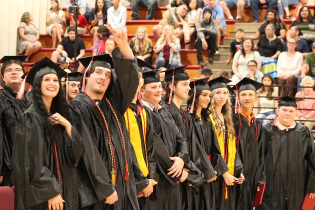 Earlsboro graduate Danney Billingsley III gestures to someone in the audience as others smile after receiving their diplomas during the commencement on May 10. Earlsboro graduated 19 seniors this year. Countywide &amp; Sun/Natasha Dunagan