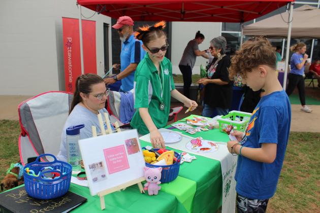 Bethel 4-H Vice President Ember Luna shows Cooper Eagleston, 9, of Tecumseh, the next step in her game of choosing what is good to feed cats or dogs, as her mom Danielle watches, during the Healthy Kids/Pups &amp; Pals event at the Shawnee YMCA, June 1. Luna won second at the 4-H Be the Best Speech Contest in Ada with her game and speech on edible and non-edible foods for pets. Countywide &amp; Sun/Natasha Dunagan