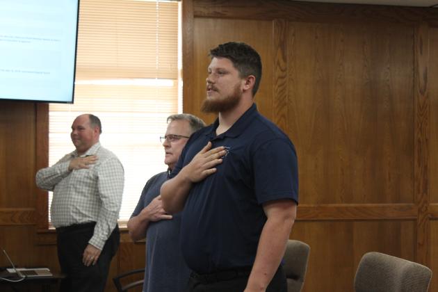 Tristan Wyatt, Director of Finance, leads the flag salute.