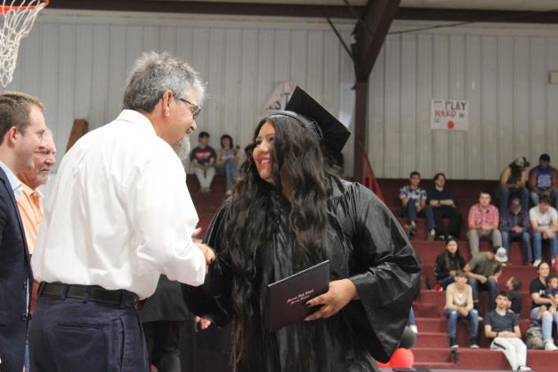 Macomb graduate Stephanie Rivera-Jimenez shakes hands with retired science teacher Wayne Howard after receiving her diploma on May 4. Howard was one of two guest speakers at the commencement, along with Nathan Floyd. Macomb graduated 17 seniors this year. Countywide &amp; Sun/Natasha Dunagan