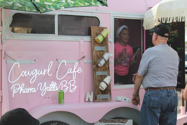 Pharra Neiman, 11, of Tecumseh, takes an order for the Cowgurl Cafe - which was run with her siblings, Yatta, 8, and BB, 6 - during the amateur barbecue contest of the Mingle on Main Street Block Party in Tecumseh on June 20. Their mother, Shiane Neiman, said besides their food truck, they also teach riding lessons. Countywide &amp; Sun/Natasha Dunagan