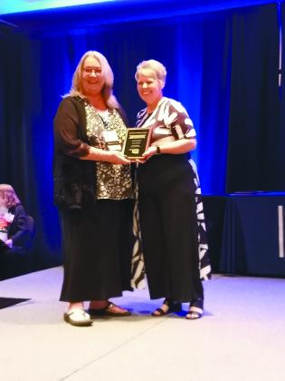 Countywide &amp; Sun Owner &amp; Publisher Suzie Campbell, left, accepts one of three first-place awards she won in the 2023 OPA Better Newspaper Contest during the OPA Convention in OKC on June 8. Presenting the award is OPA President Sheila Gay. Countywide &amp; Sun/Natasha Dunagan