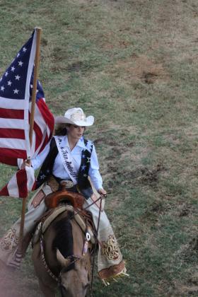 Miss Teen Rodeo USA prepares to carry the US flag in the arena.