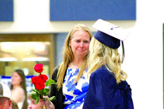 Asher Graduate Charlee Crowley shares roses and a moment during graduation on May 11. Countywide &amp; Sun/Natasha Dunagan