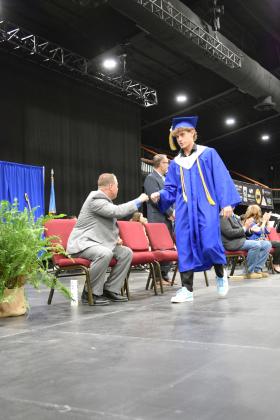 Coach Joey Ginn fist bumps Bethel graduate, RJ Morris, as he walks towards his diploma on May 18th.  Countywide &amp; Sun/Julie Talton