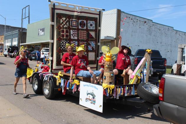 The Sewing Circle Bees of McLoud toss candy to the crowd from their float in the McLoud Blackberry Festival Parade on July 13. There were 75 entries in the parade this year, and they won second place, along with First United Methodist Church. First Baptist Church of McLoud got first, and Kickapoo Head Start won third. Countywide &amp; Sun/Natasha Dunagan