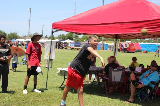 Wyatt Harjo, of McLoud, gives his best pitch to dunk Youth Football Coordinator Jonathan Raper during the McLoud Blackberry Festival on July 13. Proceeds went to the Youth Football and Cheer programs. Countywide &amp; Sun/Natasha Dunagan