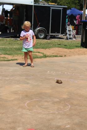 Kylan Trail, 5, of McLoud, watches as her turtle reaches the finish line in the concert area on July 13. Trail was the only participant in the McLoud Blackberry Festival's Turtle Race. Other children's games were offered, as well. Countywide &amp; Sun/Natasha Dunagan