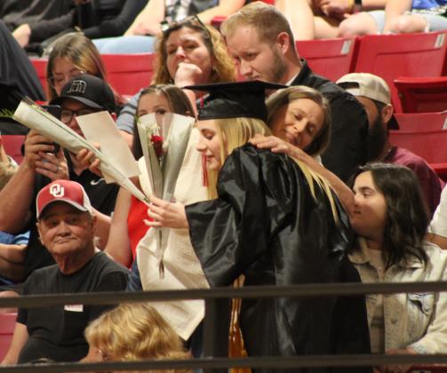 Earlsboro Graduate Nikki Johnson shares a flower and gets a hug during graduation on May 10. Johnson, Kaitlyn Chambers and Aubree Wilkins were Valedictorians. Countywide &amp; Sun/Natasha Dunagan