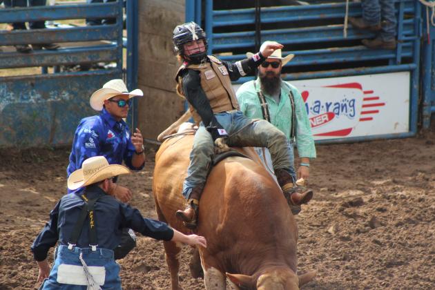 Ethan Winckler, of Winnie, TX, makes his first bull ride in the International Finals Youth Rodeo on July 8 and earns a 78.5. The bullfighters are, from left, Randy Miller, Jud Napier and Mark Weber. Countywide &amp; Sun/Natasha Dunagan