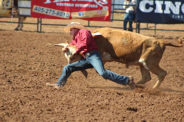 Trey Weekley, of Southwest, FL, doesn't give up when his steer has other plans, but runs alongside it trying to twist it to the ground, July 10, at the International Finals Youth Rodeo. Countywide &amp; Sun/Natasha Dunagan