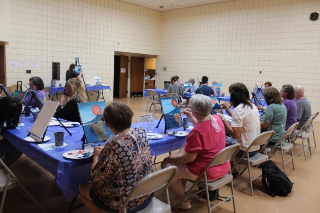 About 16 people follow the steps to copy a painting, as directed by Jordyn Wiley, of Pinot's Palette in Norman, on July 25. The painting class was held at the Tecumseh City Hall Auditorium as a program of the Tecumseh Pioneer Library Systems Summer Reading Challenge. The next "Painting Together - Step By Step" class will be for teens ages 12-17 on July 10 at 2 pm. For more information, visit https://pioneer.libnet.info/events?r=thismonth. Countywide &amp; Sun/Natasha Dunagan