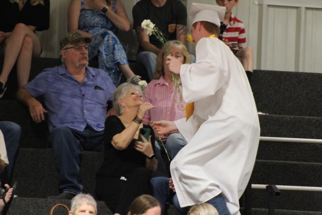 Maud Salutatorian Cooper Nance presents a carnation during graduation on May 17. Countywide &amp; Sun/Natasha Dunagan