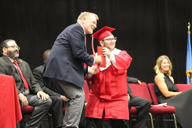 McLoud Graduate Denim Gathright receives his diploma from School Board Member Doug VanScoyoc on May 18. Countywide &amp; Sun/Natasha Dunagan