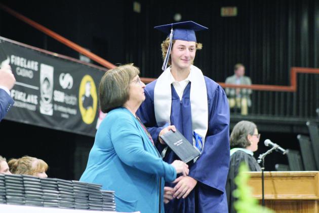Shawnee School Board Member Mandy Hillhouse looks up to Noah Cluck after presenting his diploma during the 126th Shawnee High School Commencement Ceremony on May 16 at FireLake Arena. Countywide &amp; Sun/Natasha Dunagan