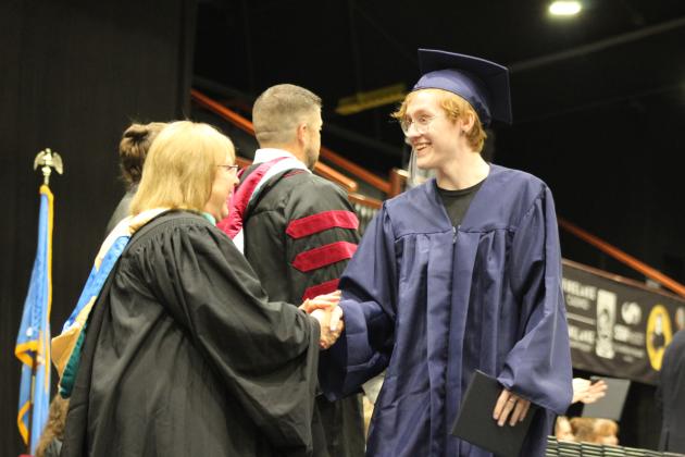 Shawnee Graduate Beau Armitage shakes hands with retiring Alternative Education Director Deborah Watson during the 126th Shawnee High School Commencement Ceremony on May 16 at FireLake Arena. Countywide &amp; Sun/Natasha Dunagan