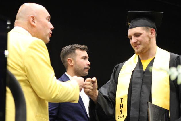 Tecumseh Superintendent Robert Kinsey gives Jacob Frazier a fist bump after Frazier received his diploma at graduation on May 21. Also shown is School Board Member Dylan Hays. Countywide &amp; Sun/Natasha Dunagan