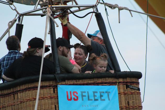 Katy Risley, 6, looks out of the hot-air balloon basket as she and her aunt Courtney Riley, both of Bartlesville, take a tethered ride on Friday, Aug. 9, at the FireLake Fireflight Balloon Festival. Countywide &amp; Sun/Natasha Dunagan