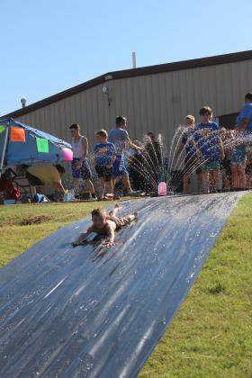 Sawyer Billins, 6, of Bethel, takes his turn on the slip n' slide, a fund-raiser for the Bethel Little League Cheer program, on Aug. 17. This was one of several booths, including a dunk tank fund-raiser for Bethel Wrestling, at the Bethel High School Blue &amp; Gold Bash held at the football field. Countywide &amp; Sun/Natasha Dunagan