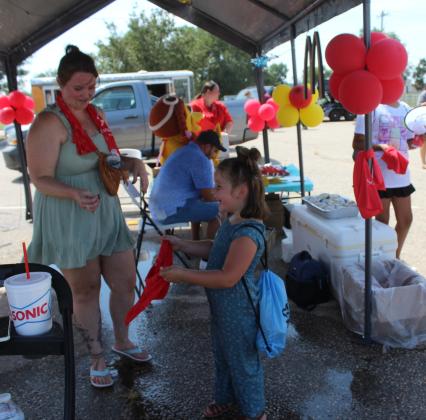 Piper Deckard, 5, of Choctaw, laughs as she wets her cooling towel in the McDonald's mist tent and Alexis Atkison looks on at the Sixth Annual Cops n' Kids, held on Aug. 24 at the Heart of Oklahoma Expo Center. The towels were donated by Sovereign Bank and given away at the booth. McDonald's also gave away sausage biscuits. Countywide &amp; Sun/Natasha Dunagan