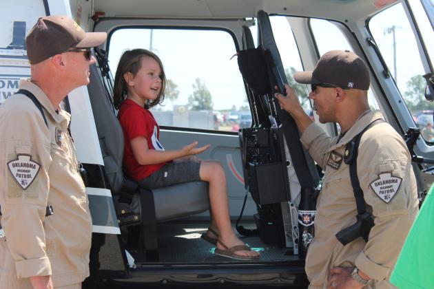 Trooper Paul Lakin and Trooper Tyrie Haught, both helicopter pilots with the Oklahoma Highway Patrol, listen to Kaydin Bird, 5, of Shawnee, talk about a video game at the Sixth Annual Cops n' Kids, held on Aug. 24 at the Heart of Oklahoma Expo Center. About 40 law enforcement and first responder groups and 50 organizations attracted approximately 3,000 people to this year's event. Countywide &amp; Sun/Natasha Dunagan