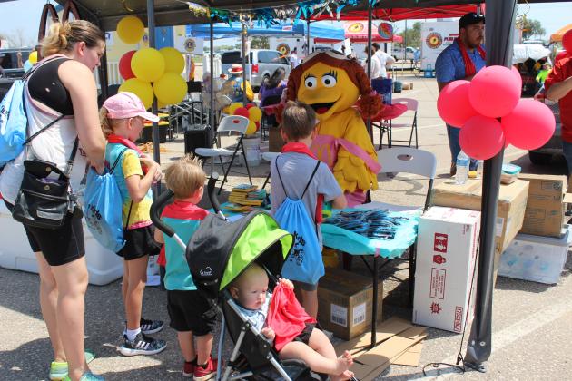 Phoenix Keffer; Kerrigan Hess, 7; Dominic Keffer, 3; Ashtyn Keffer, 5; and Ryker Keffer, nine months, all of Shawnee, say hello to "Birdie" at the Shawnee McDonald's booth during the Sixth Annual Cops n' Kids, held on Aug. 24 at the Heart of Oklahoma Expo Center. All of the children are wearing cooling towels, which were donated by Sovereign Bank and given out at the booth, that was also a mist tent. Countywide &amp; Sun/Natasha Dunagan