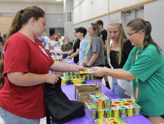 Miss Frontier Days Aleigha McCullough and Ella Whitney hand out colored pencils and Play Dough at the Mission Tecumseh Back to School Bash, held at the WP Wood/THS Alumni Center on July 27. Mission Tecumseh Board Member Anthony LaGrange said they gave away the 549 backpacks they had available in the first hour and continued to hand out school supplies at eight stations until those ran out.