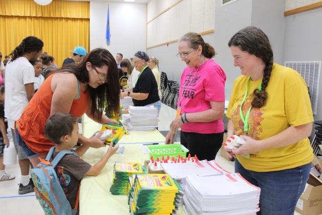 Donna Wasson and Beth Lyle hand out markers and glue at the Mission Tecumseh Back to School Bash, held at the WP Wood/THS Alumni Center on July 27. Mission Tecumseh Board Member Anthony LaGrange said they gave away the 549 backpacks they had available in the first hour and continued to hand out school supplies at eight stations until those ran out. LaGrange estimates they had 700 to 750 people come through the event, with about 50 volunteers from the community working it. Countywide &amp; Sun/Natasha Dunagan