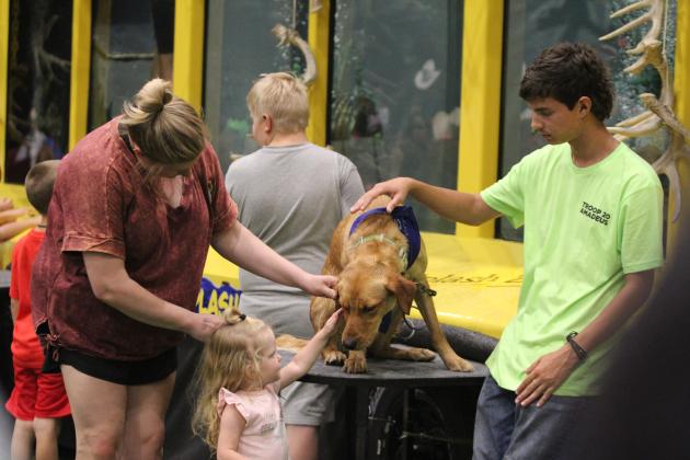 Harper Hamrick, 2, and her mom, Kelli Hamrick, of Ponca City, pet one of the dogs at the Fetch N' Fish Dog Show, during the Outdoor Network Expo at FireLake Arena on Aug. 9. Countywide &amp; Sun/Natasha Dunagan