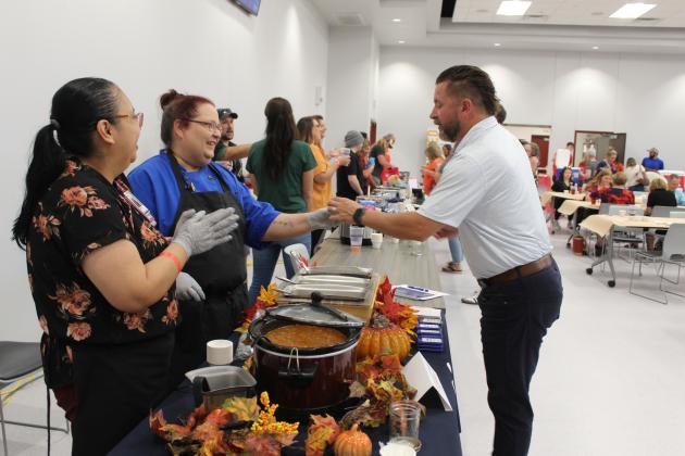 SSM Health St. Anthony Hospital Lead Cook Sarah Davis, center, hands a bowl of "Old-Fashioned Chili" to United Way Kickoff Cookoff Judge Michael Affentranger, as Food Service General Manager Nadine Hill, far left, watches. There were 21 entries from non-profits, businesses and churches in the second annual chili cookoff on Aug. 27. Countywide &amp; Sun/Natasha Dunagan