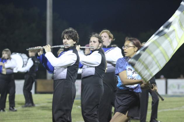 Pride of Bethel band members Cayden Ricker, Nathan Ricker, and Elijah Robertson perform music from the Blues Brothers, as color guard member Patience Stell dances around them with her flag, during the Sept. 6 football game halftime. Countywide &amp; Sun/Natasha Dunagan