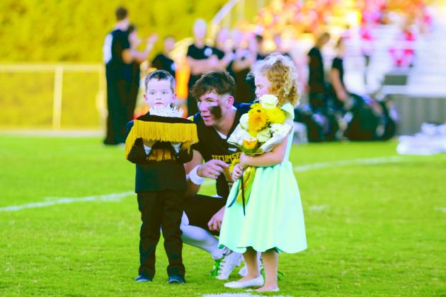 Tecumseh senior Kaeson Pine talks with Crown Bearer Briggs Litle, as Flower Girl Tegan Cleere stands by during the Tecumseh High School Fall Homecoming ceremony on Sept. 20. The crown and flowers would go to senior Katie Overstreet. Countywide &amp; Sun/Natasha Dunagan