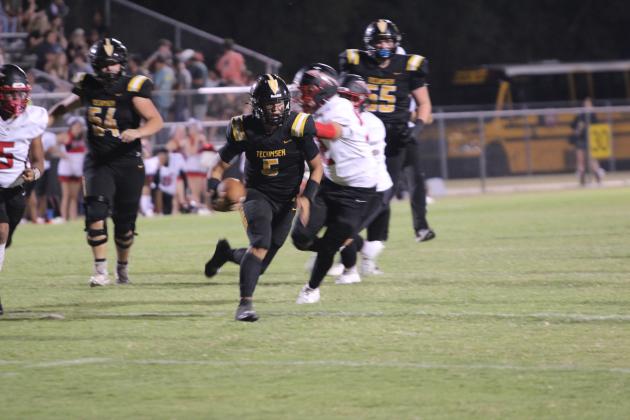 With a quarterback keeper, Tecumseh senior Hollin Barnes dashes to within two yards of the end zone in the second quarter of the game with McLoud on Sept. 20. In the next play, senior Braxton Meier took it the rest of the way for a touchdown. The Savages fought the Redskins and emerged victorious with a score of 35-34. Countywide &amp; Sun/Natasha Dunagan